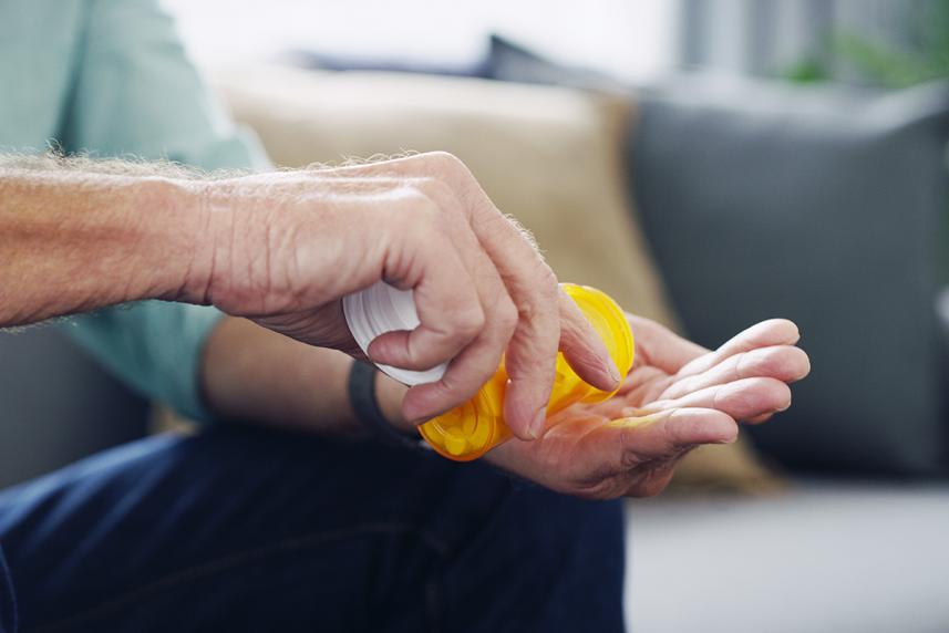 Closeup of man's hands taking medication