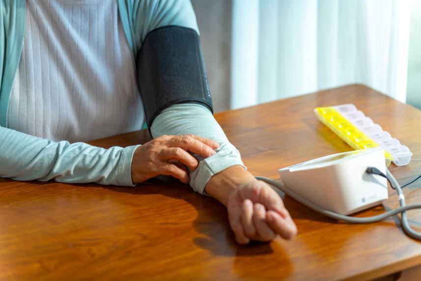 Older woman taking blood pressure at home